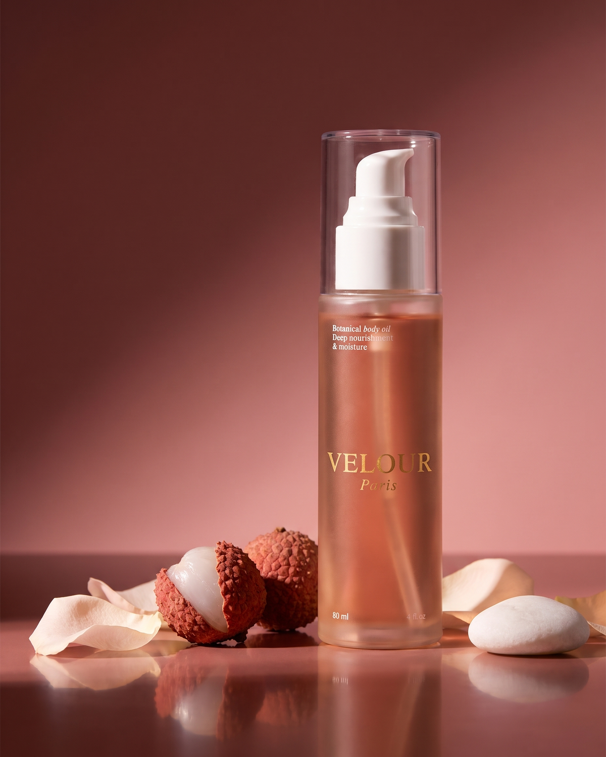 VELOUR Paris Ambre : flacon d'huile ambrée et pompe dorée, posé près d'un flacon de parfum rose orné de pompons.